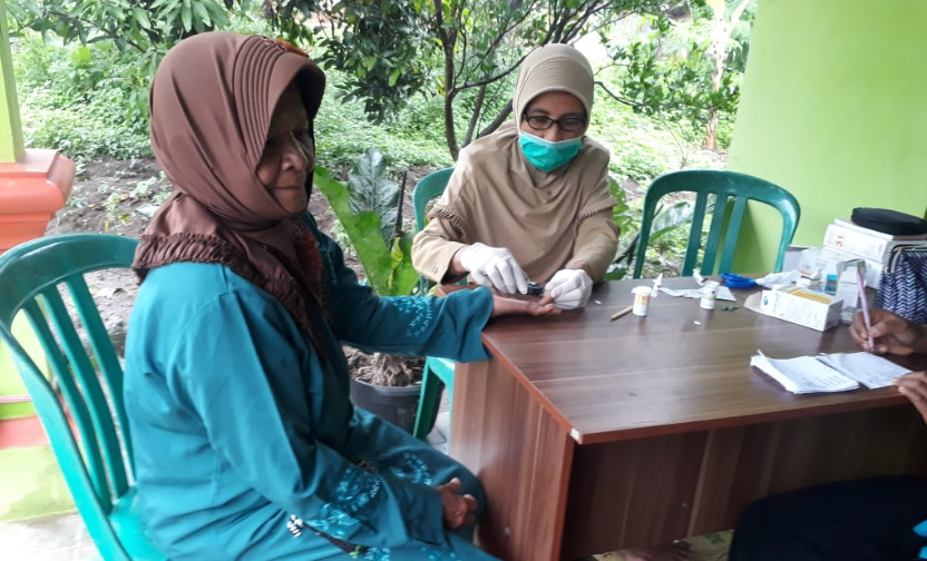 Tenaga kesehatan posyandu melayani pemeriksaan pasien lansia