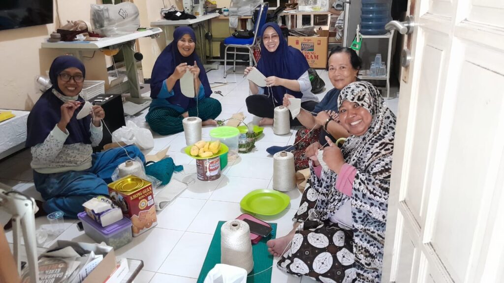Yuni Suwanti Asih atau yang akrab dipanggil June SA hijab biru tua berkacamata tengah, saat bersama pengerajin rajut di kediamannya Pondok Sidokare Indah, Sidoarjo,Rabu(4/9/2024)(Foto: Dian/Etara.id).