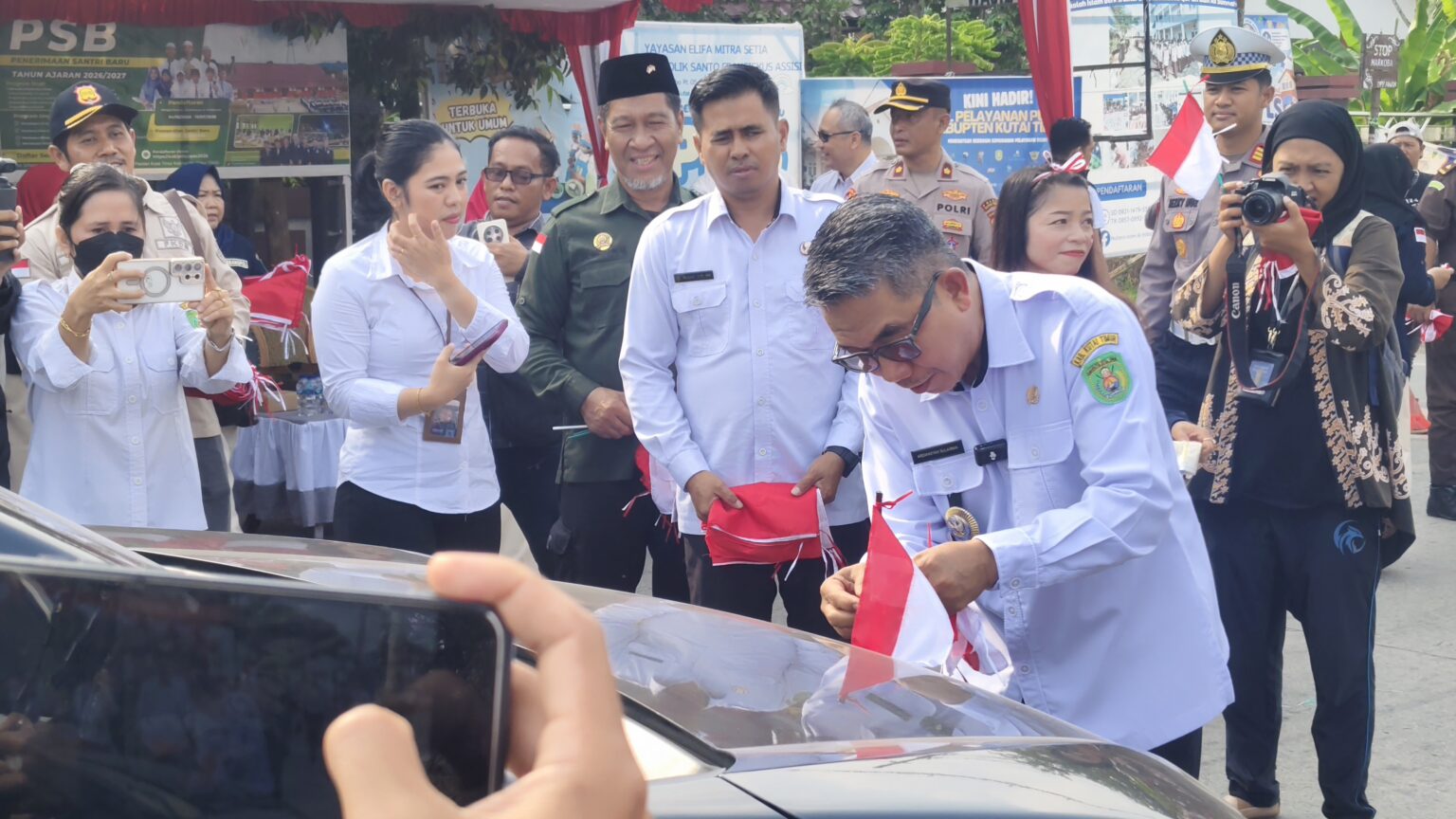 Ardiansyah Sulaiman, Bupati Kutim saat membagikan bendera merah putih pada pengendara di kawasan Simpang Tiga Pendidikan, Rabu (12/8/2026)